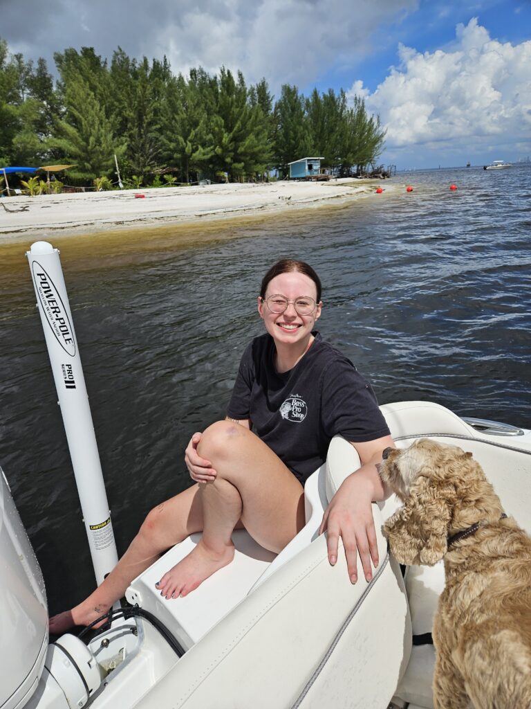 Shawna Calvert's daughter on the back of the boat with Winchester, the family dog, beside a Florida sandbar