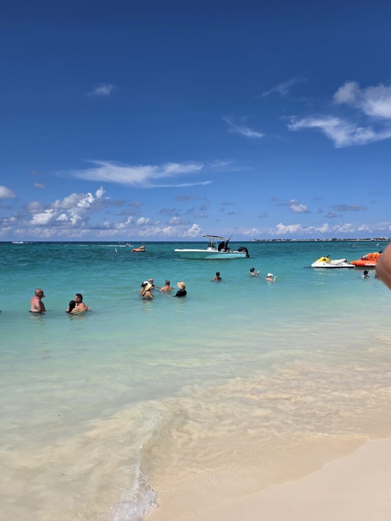People swimming in clear turquoise water off a Florida beach