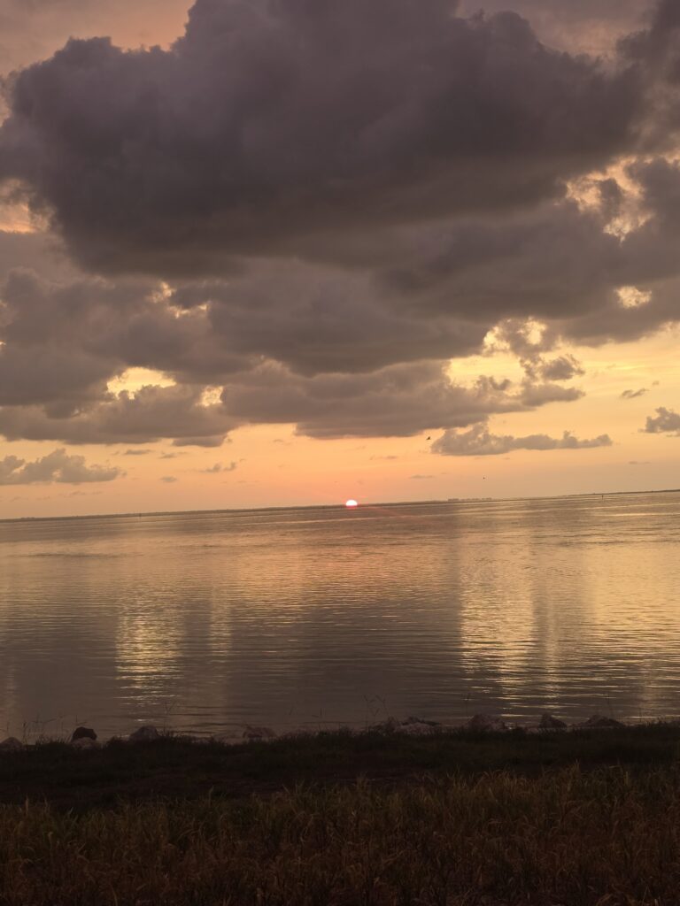 Sunset over calm water under dramatic clouds on the Florida Gulf Coast