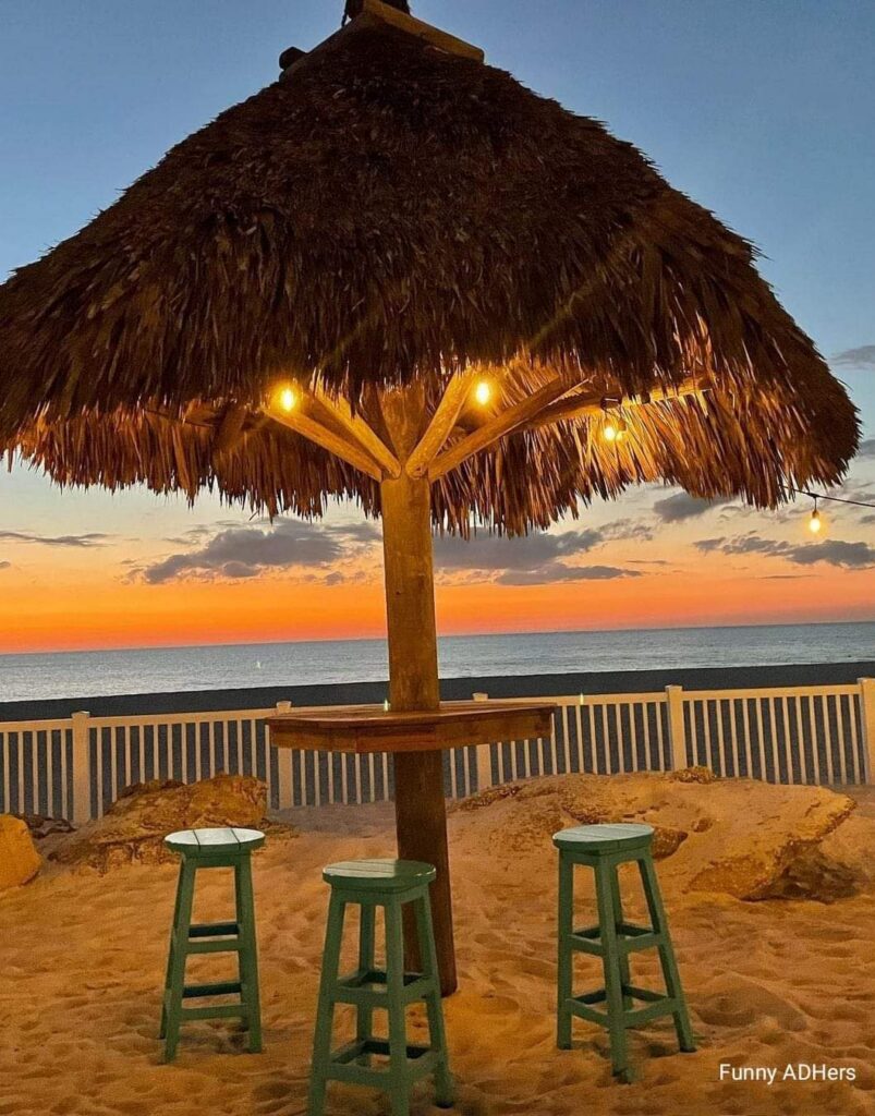 A tiki bar lit up at dusk beside the water in Florida