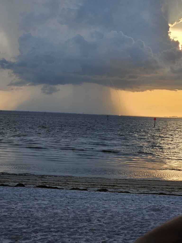 A rain squall moving across the water under dark clouds in Tampa Bay