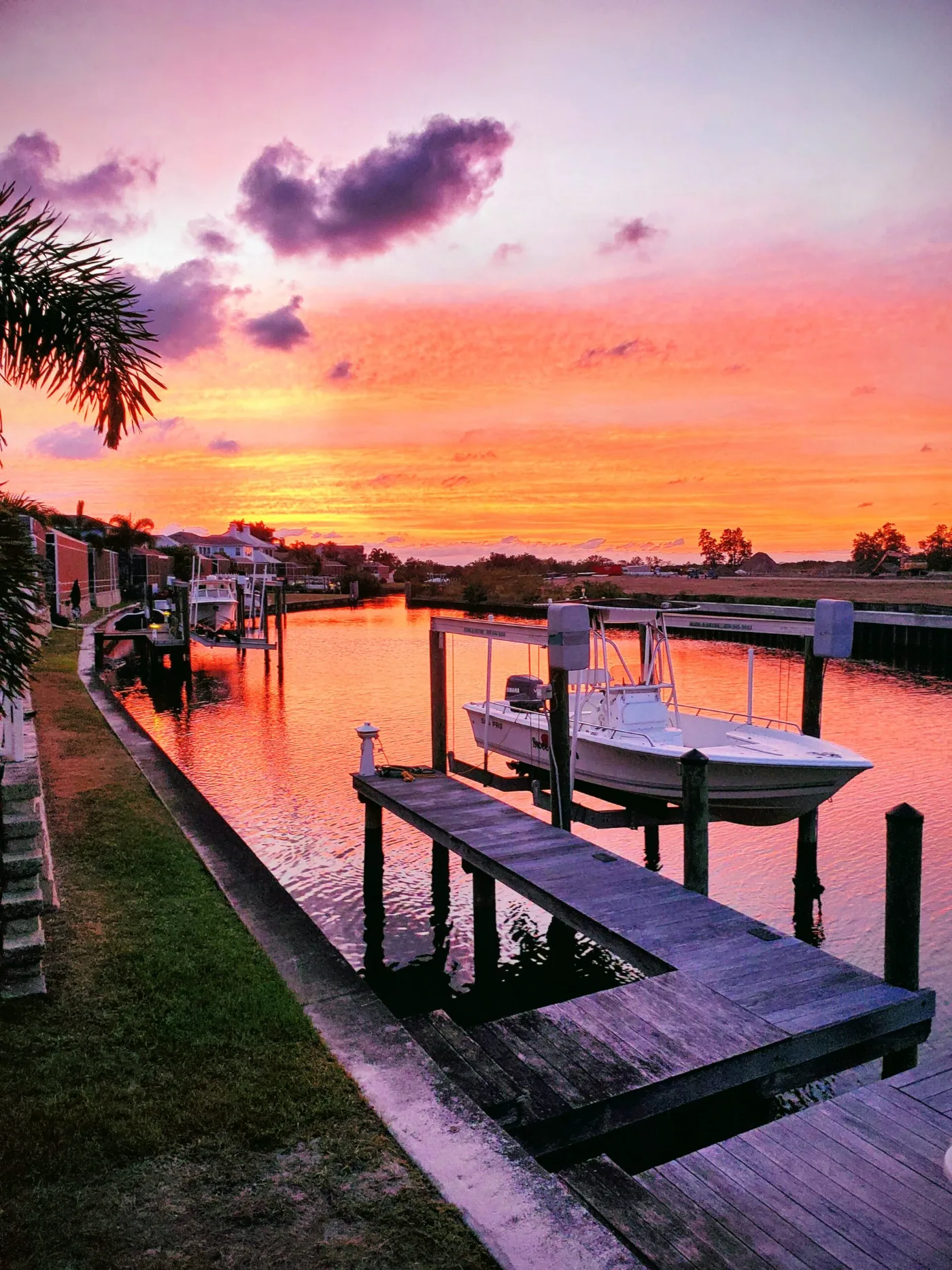 Boat on a lift at a private dock on an Apollo Beach canal at sunset