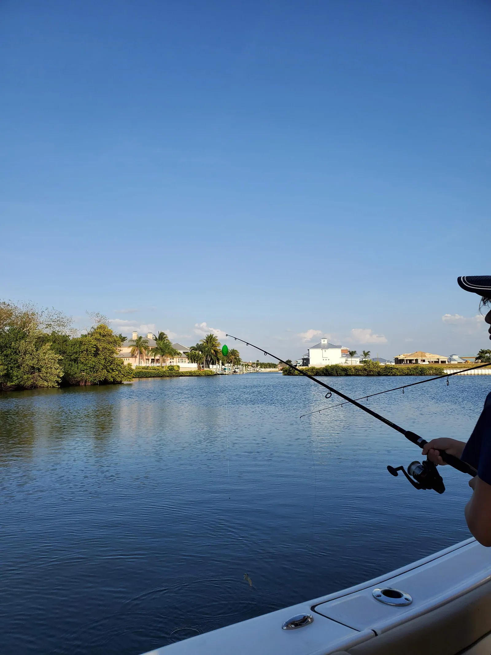Fishing from a boat on an Apollo Beach canal lined with waterfront homes
