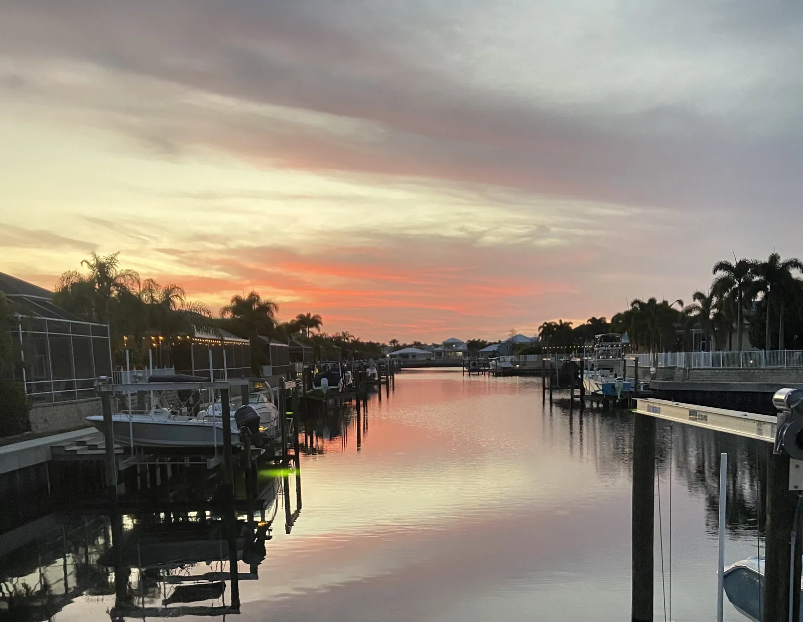 Sunset over an Apollo Beach canal lined with private docks and boat lifts