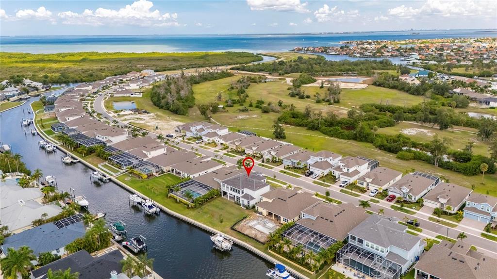 Aerial of 1016 Signet Drive in the Marisol Pointe section of MiraBay, Apollo Beach, on a saltwater canal with Tampa Bay beyond