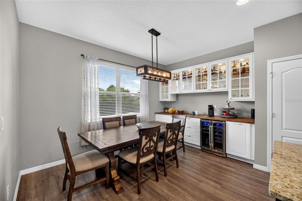 Dining area with built-in dry bar and wine fridge