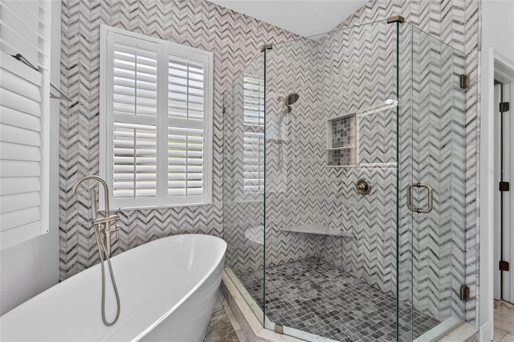 Remodeled primary bath with floor-to-ceiling tile