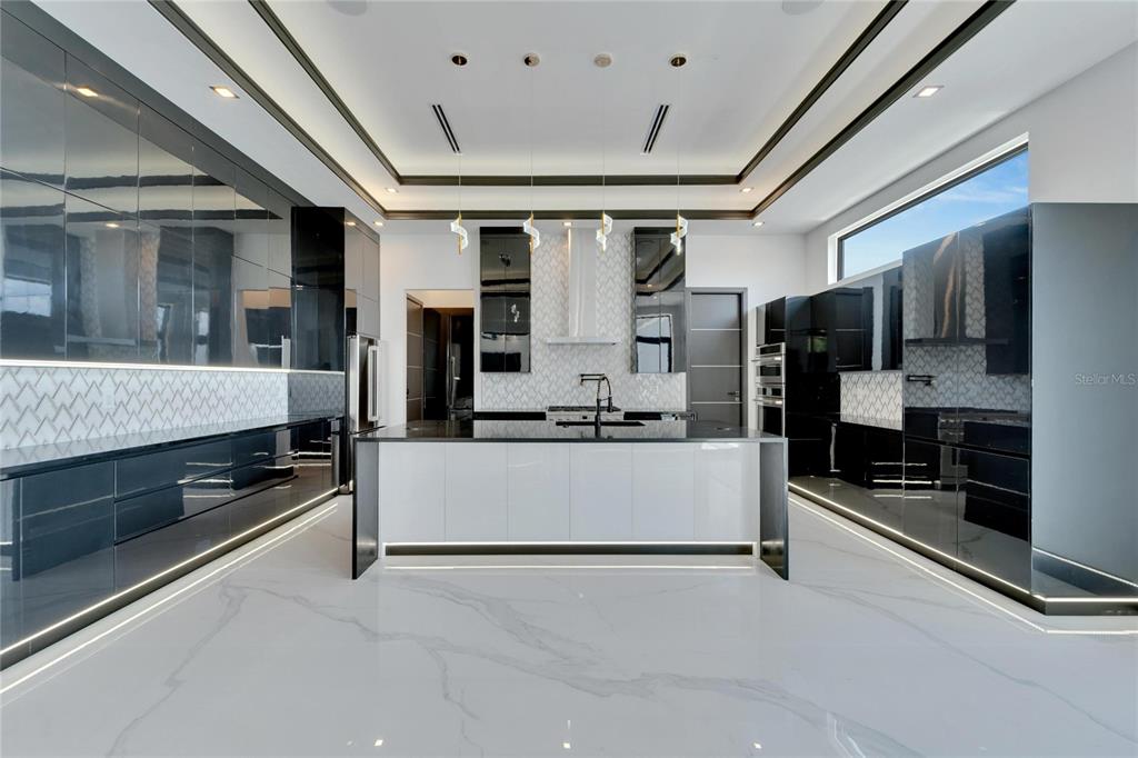 Kitchen with waterfall quartz island and custom cabinetry at 517 Treviso Drive