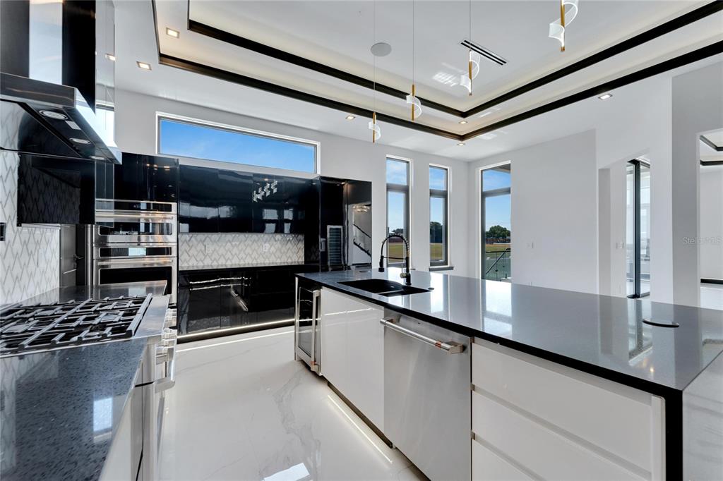 Kitchen with gas range, pot filler and built-in appliances at 517 Treviso Drive