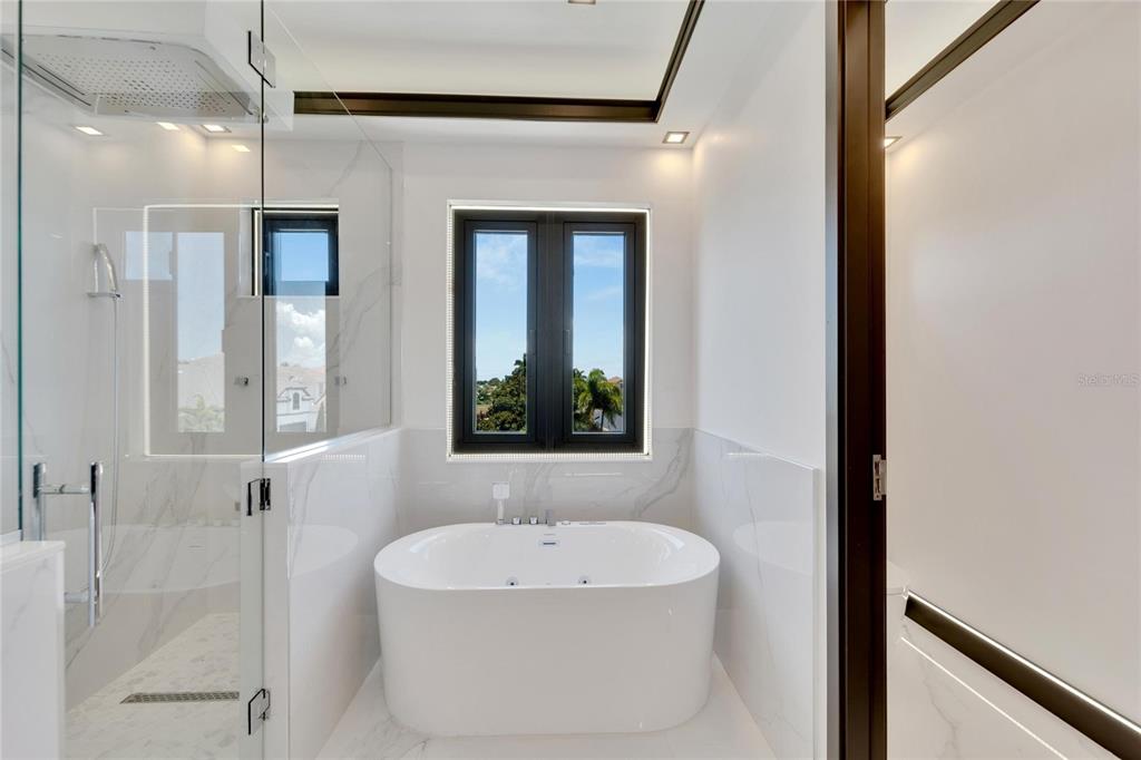 Primary bath with garden tub and custom shower at 517 Treviso Drive