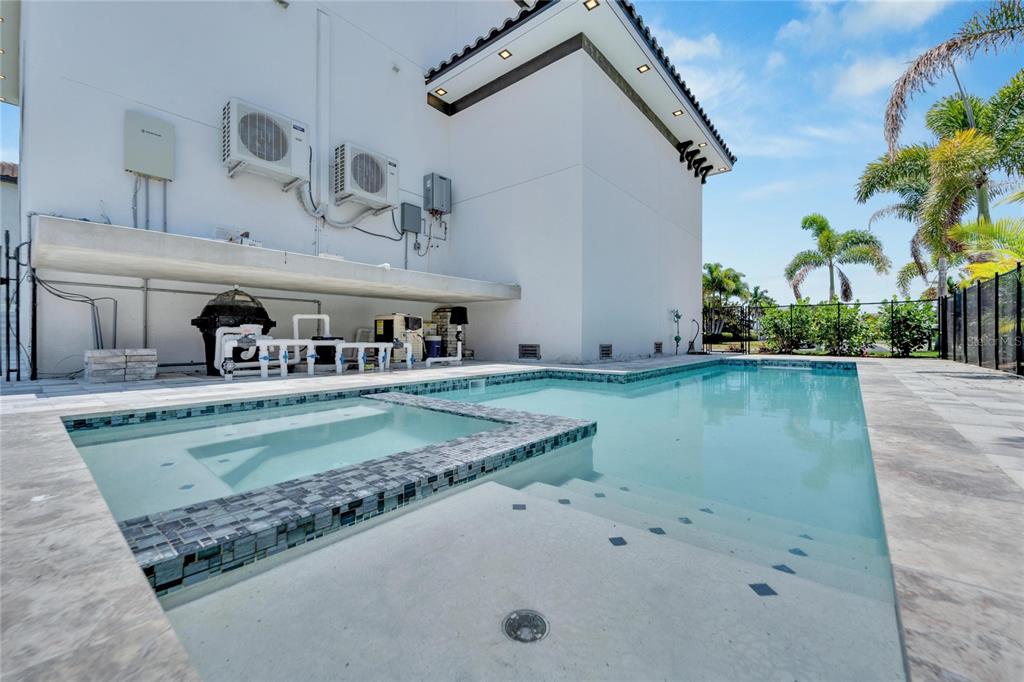 Pool, spa and covered lanai with outdoor kitchen at 517 Treviso Drive