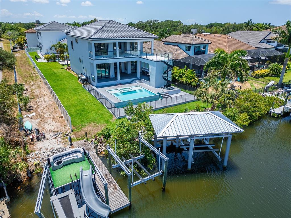 Aerial of 517 Treviso Drive showing the pool, backyard and private dock on the saltwater canal