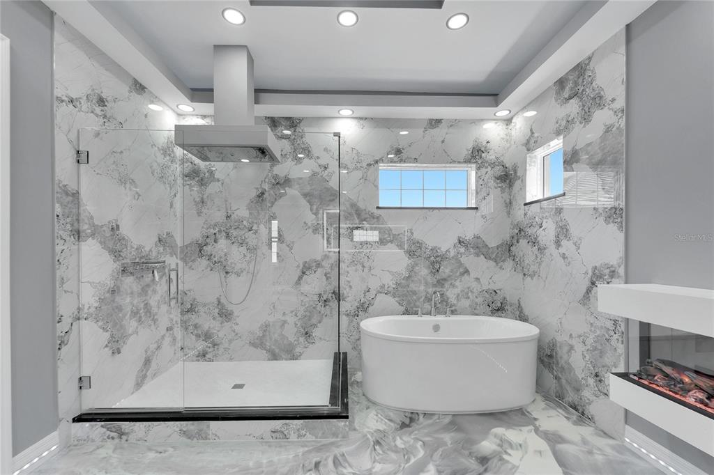 Primary bath with freestanding tub and glass walk-in shower at 534 Estuary Shore Lane