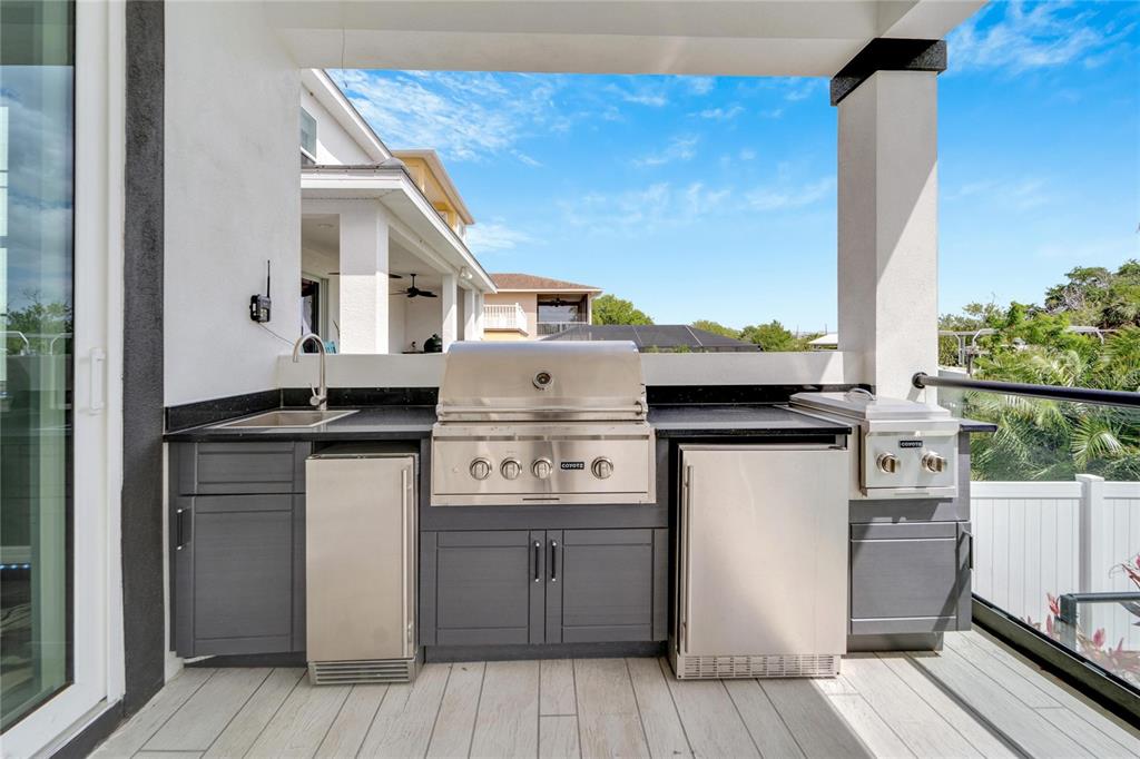 Outdoor kitchen with grill, fridge and icemaker at 534 Estuary Shore Lane