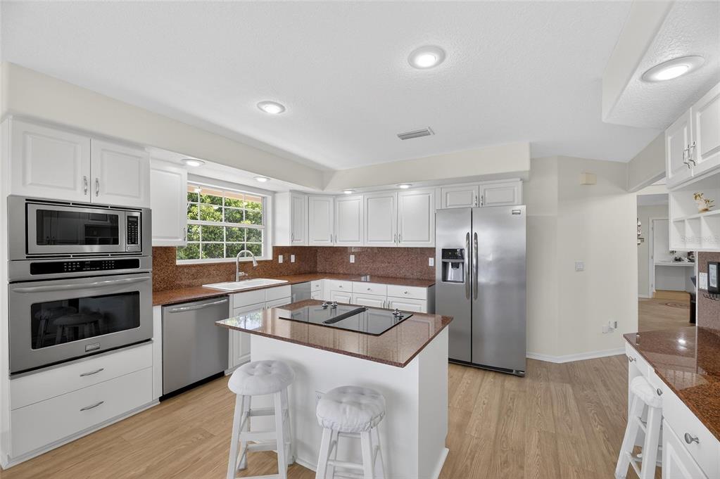 Kitchen with granite counters, stainless appliances and island
