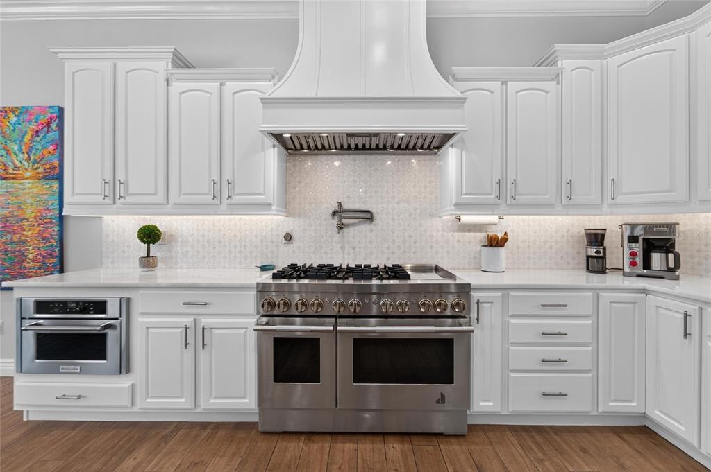 Kitchen with 48 inch Jenn Air dual-fuel range and marble counters at 6203 Marbella Boulevard