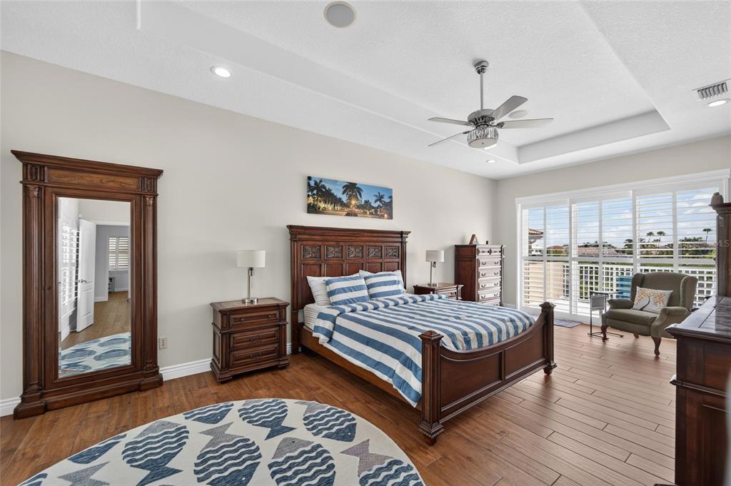 Primary bedroom with private waterfront balcony at 6203 Marbella Boulevard