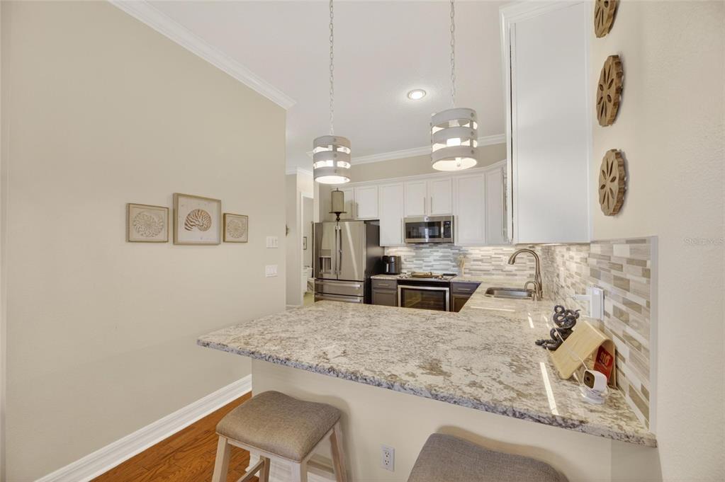 Updated kitchen with granite and glass tile backsplash