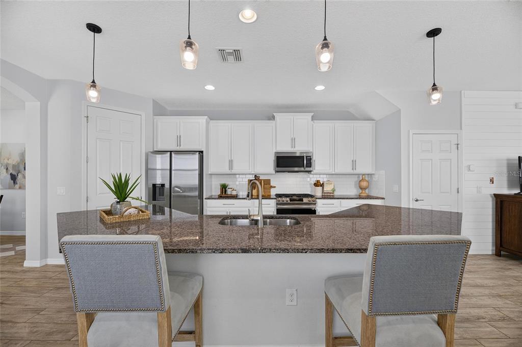 Kitchen with large island, stone counters and gas range