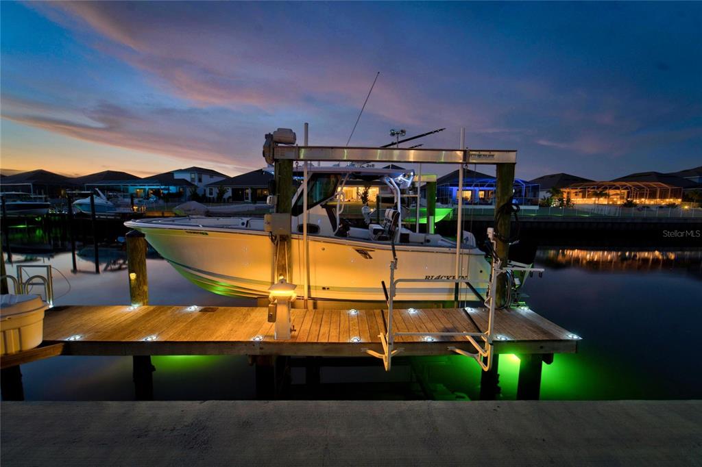 Dock and boat lift lit at night on Biscayne Canal at 713 Islebay Drive