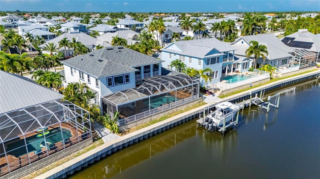 Aerial of 713 Islebay Drive in MiraBay, Apollo Beach, with the pool, dock and boat lift on Biscayne Canal