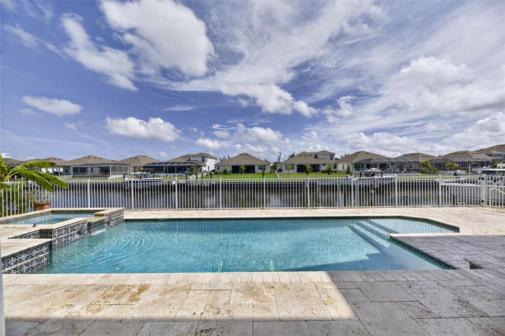 Heated pool and travertine deck overlooking Biscayne Canal at 715 Islebay Drive