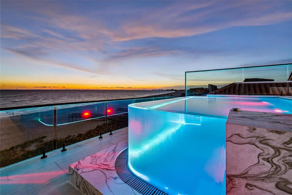 Rooftop infinity pool at dusk over the Gulf at 9600 Gulf Boulevard