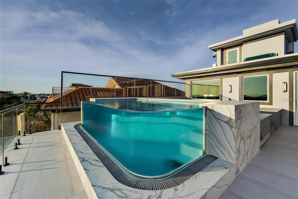 Stainless steel and acrylic infinity-edge rooftop pool at 9600 Gulf Boulevard