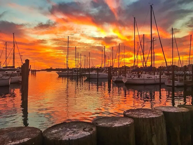 Sunset over sailboats and dock pilings at the marina beside Circles Waterfront Restaurant in Apollo Beach, Florida