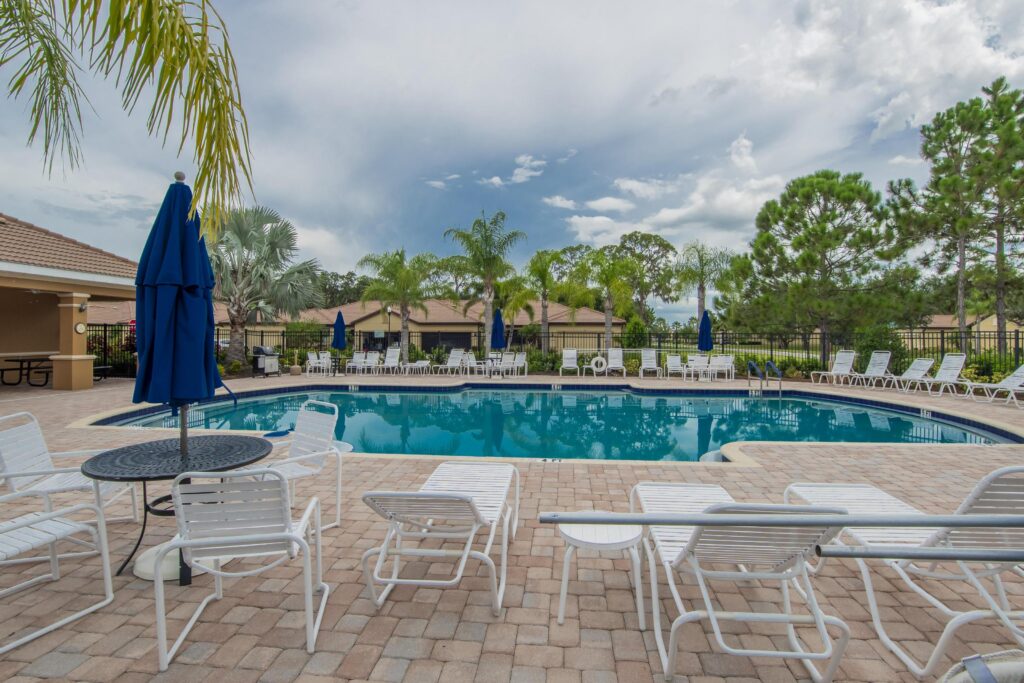 Pool deck with loungers and umbrellas at Del Webb Southshore Falls, Apollo Beach